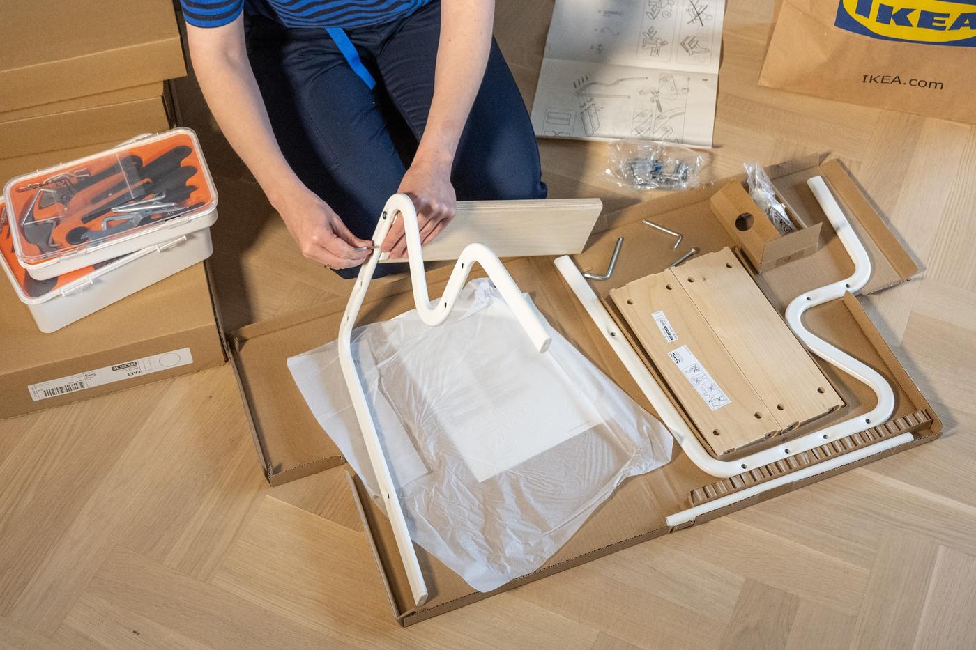 Čovek sastavlja IKEA nameštaj.