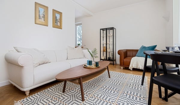 Cozy living room with white sofa, wooden coffee table, and display cabinet.