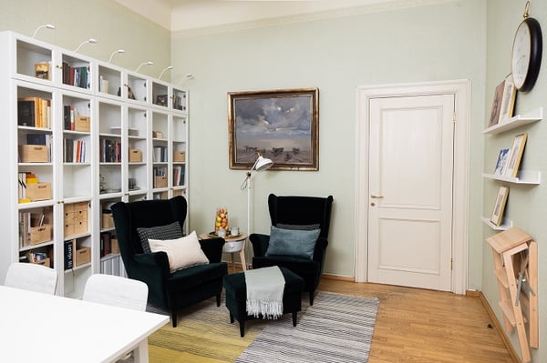 Cozy reading corner with armchairs, bookshelves, and soft lighting