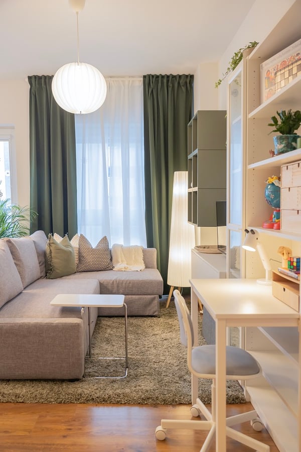 Cozy study area with desk, lamp, and shelves in modern living space.