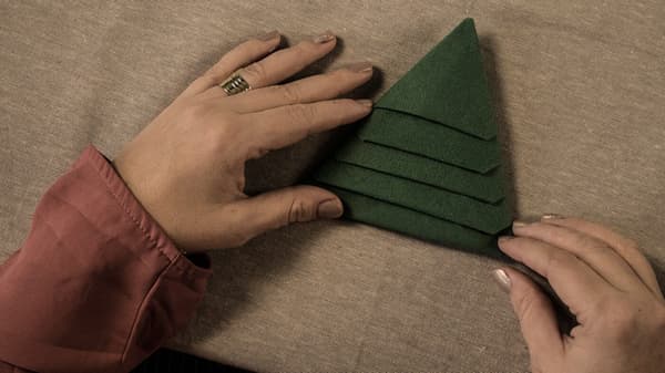 Craft instructions, the finished result: a green napkin in the shape of a Christmas tree