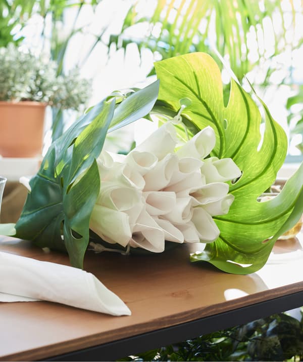 Create a pretty centrepiece for your table using a mix of plants. Hide napkins in a couple of pretty leaves that will never dry out, such as IKEA SMYCKA green artificial leaf!