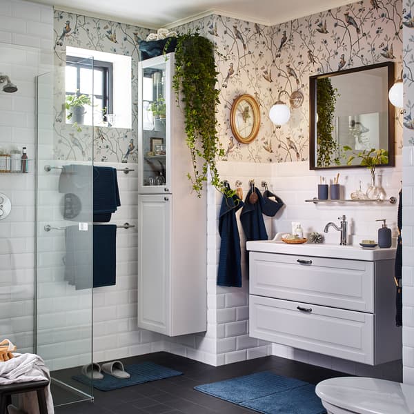 Create a relaxing atmosphere in your bathroom with IKEA GODMORGON white washbasin and white bathroom cabinet with glass doors. LILLHOLMEN nickel-plated wall lamps give a soothing warm glow for morning and night.