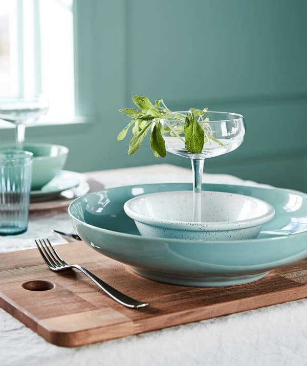 Créez une table estivale dans un mélange de verts clairs et de blancs purs. Choisissez une vaisselle vert clair, comme le bol vert clair IKEA ENTYDIG