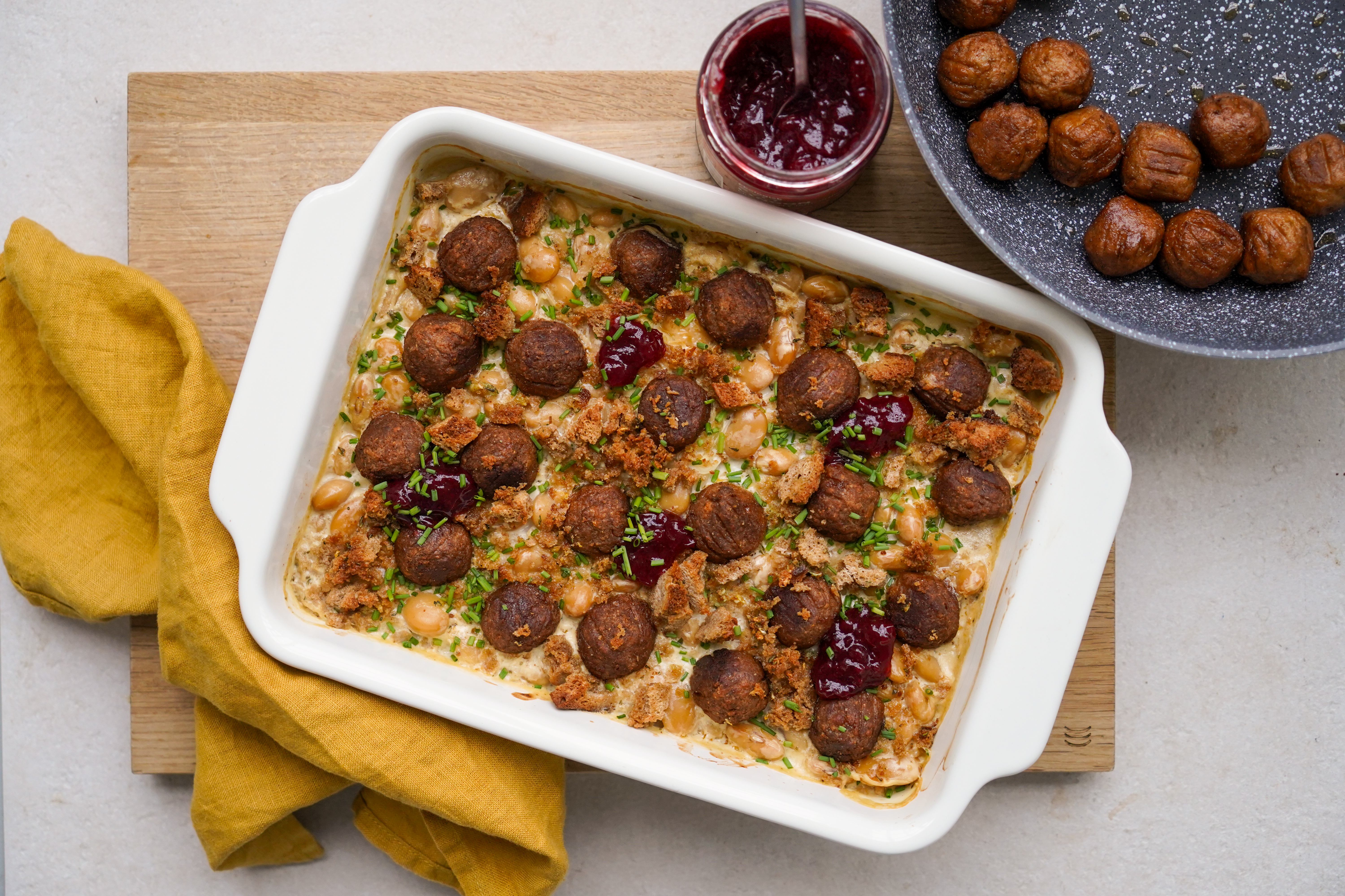Cremiger Plantball–Butterbohnen-Auflauf mit Kräuterbrösel in einer weißen Auflaufform serviert
