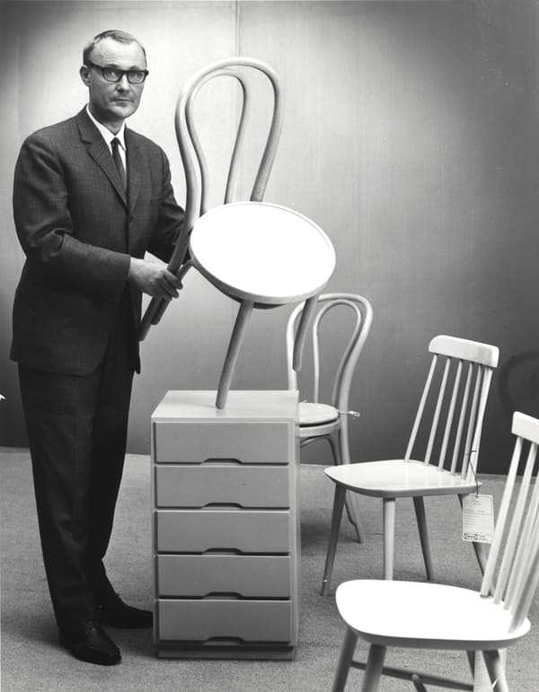 Črno-bela fotografija mladega Ingvarja Kamprada, ki v studiu drži stol podjetja IKEA. 