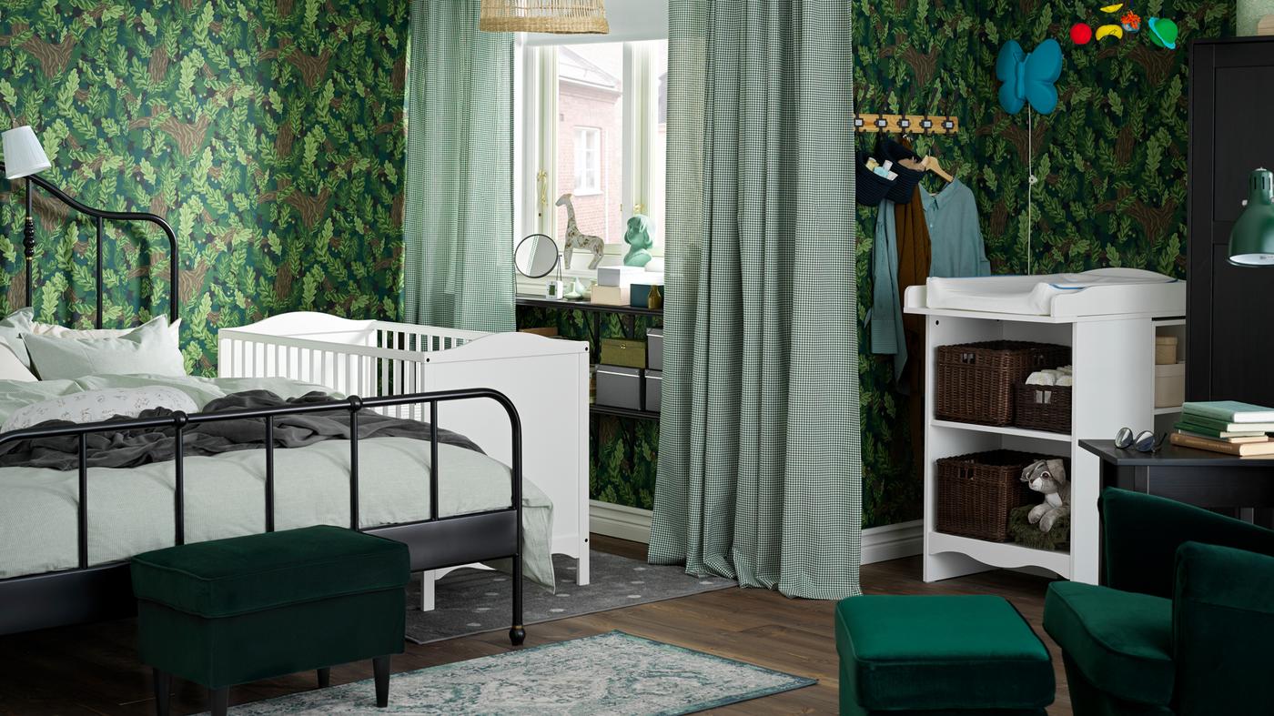 Családi hálószoba, ahol egy SAGSTUA dupla ágy áll egy fehér SMÅGÖRA rácsos ágy és egy SMÅGÖRA pelenkázó asztal mellett.