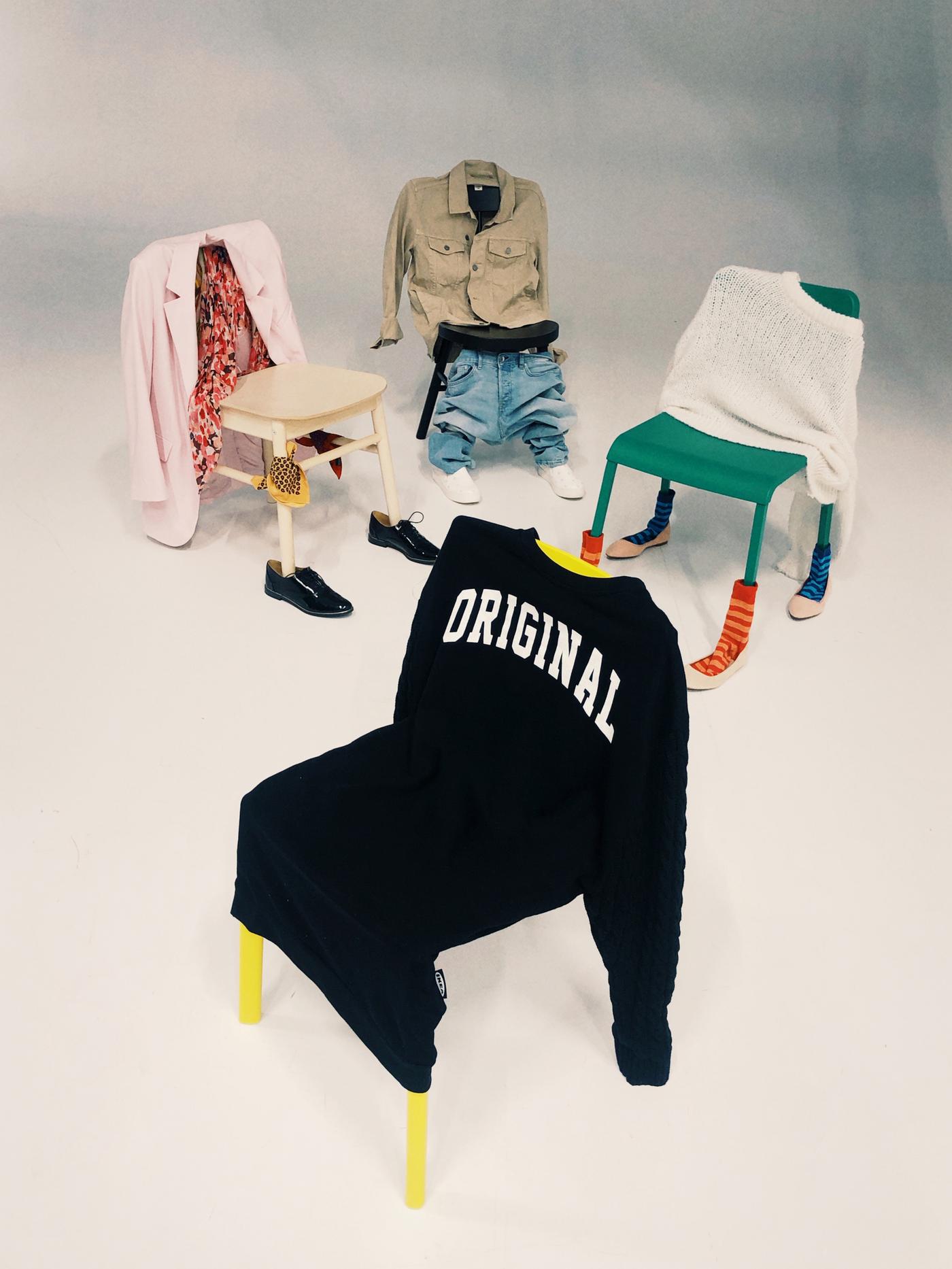 Cuatro sillas colocadas en círculo, cada una con ropa puesta como si fueran personas. La que está delante lleva la sudadera SAMMANKOPPLA.