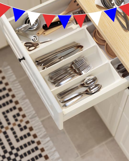 Cubiertos en un cajón de cocina organizados en una bandeja.