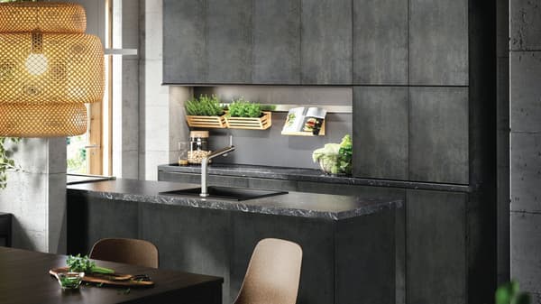 Cucina bianco sporco con piano di lavoro nero effetto minerale, lavello bianco con frontale visibile, un tavolo e due sedie nere - IKEA