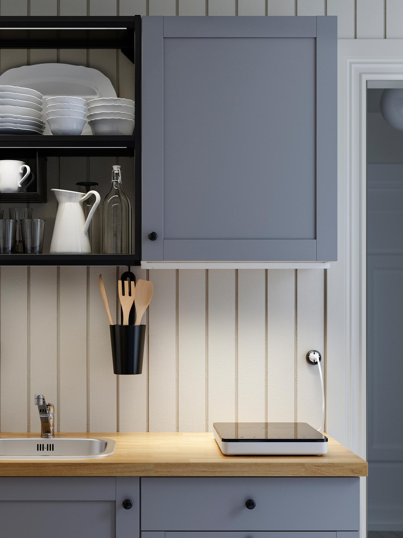 Cucina ENHET in grigio/antracite/legno, piano cottura a induzione portatile e illuminazioni a LED sopra il piano di lavoro SÄLJAN.