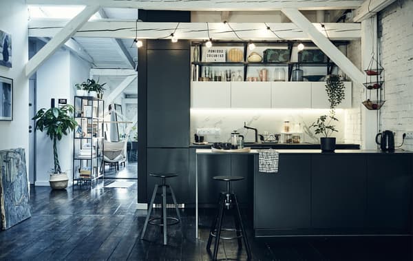 Cucina nera in un open space con travi bianche a vista e pavimenti in legno scuro - IKEA
