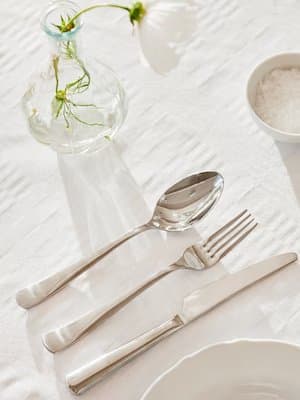 Cuillière, fourchette et couteau sur une nappe blanche