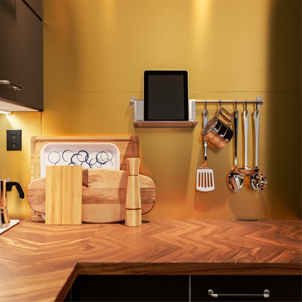 Cuisine à façade anthracite où se trouve un comptoir en noyer, une barre-support et un support à tablette en inox accrochés au mur. 