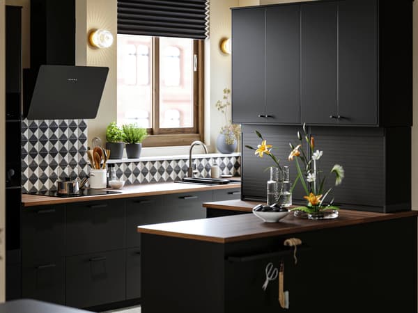 Cuisine avec portes NICKEBO anthracite, hotte murale FINSMAKARE en noir et cache-pots PERSILLADE.