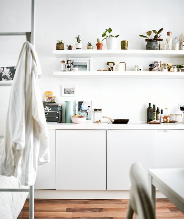 Cuisine et étagères en blanc, et échelle pour le lit mezzanine.