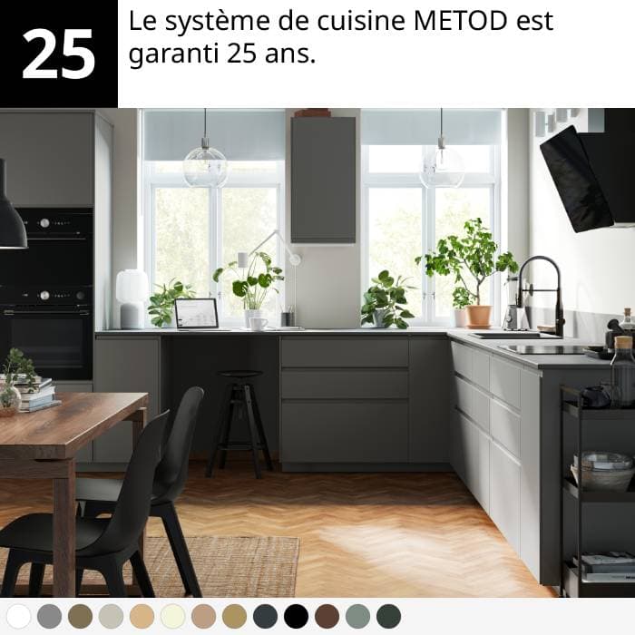 Cuisine moderne avec armoires grises, table en bois, chaises noires, plantes et sol en chevrons.