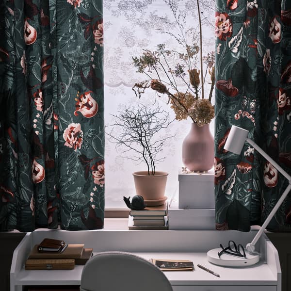 Curtains made with flower patterned FILODENDRON fabric in a window above a white HAUGA desk with a beige swivel chair.