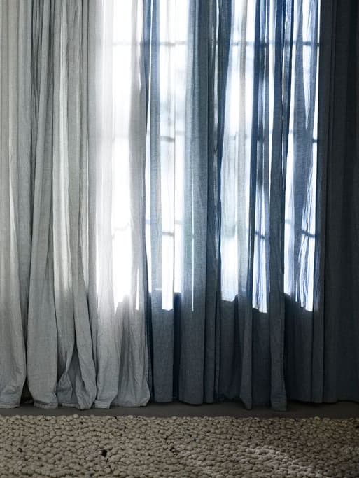 Curtains next to each other that transition from gray to blue and dark blue