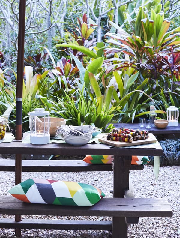 Cushions and food on an outdoor bench.