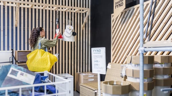 Customer shopping in an IKEA as-is department with a yellow bag on her arm.