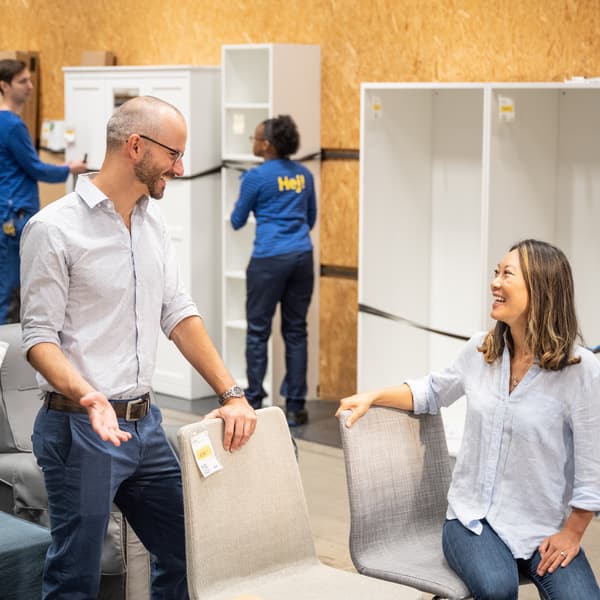 Customers looking at furniture to buy in the IKEA resell aisle.