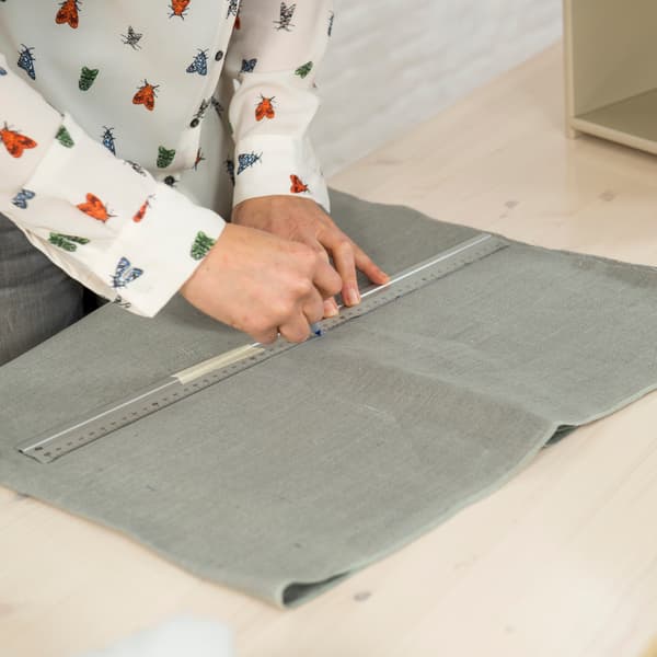 Cut a piece of fabric the size of the drawer front, plus 5 cm extra, as a cover.
