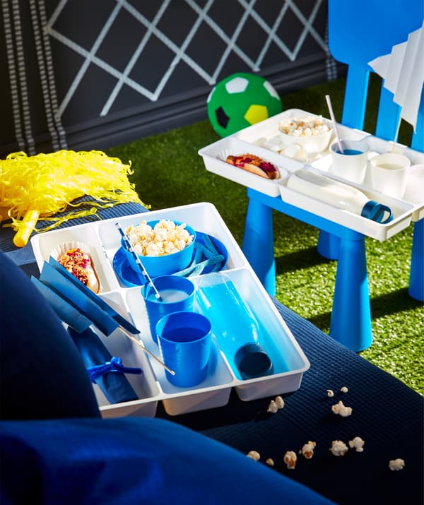 Cutlery trays used as customised food organisers for football fans, with compartments for drinks, snacks and streamers.