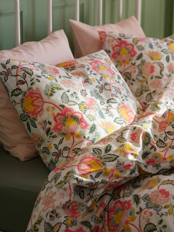 DAGGSALVIA huzatba húzott ágynemű egy ágyon, az ágyon szürkészöld DVALA gumis lepedő.