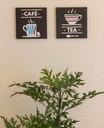 ダイニングの壁にイラストボードとグリーンを飾ってる
