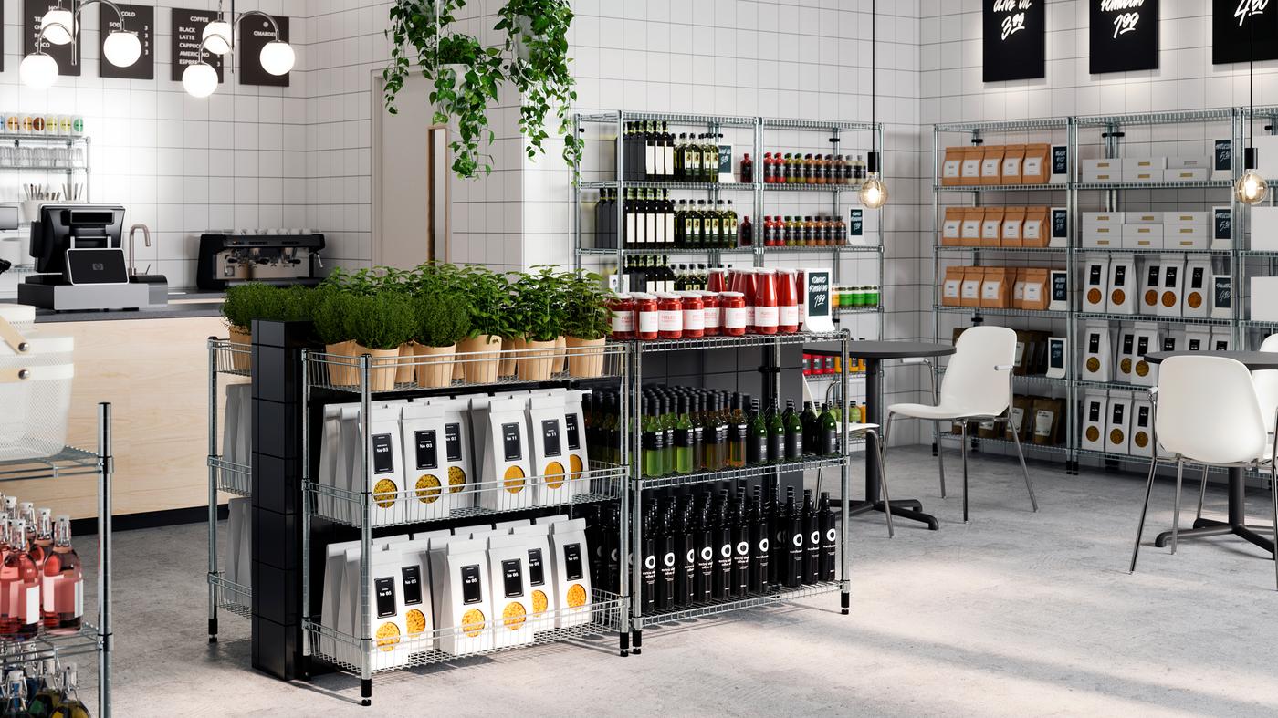 Dans un magasin à l’allure soignée, des emballages de nourriture, des bouteilles et des plantes sont rangés sur des étagères OMAR de hauteurs différentes.