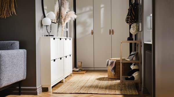 Dans un petit hall d’entrée, une armoire-penderie PAX/FORSAND d’un côté et deux armoires à chaussures STÄLL avec 4 casiers de l’autre.