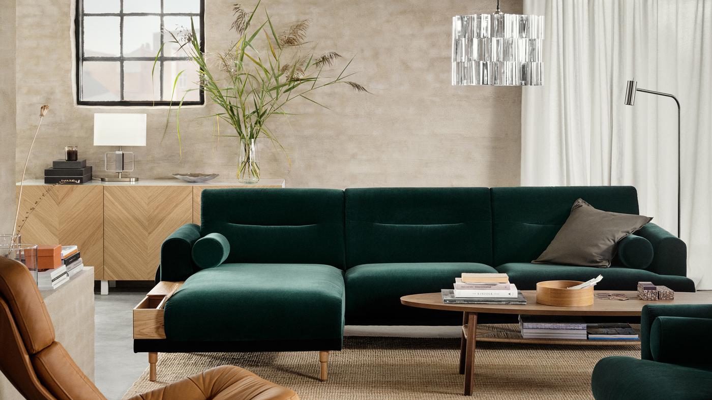 Dans un salon aéré, canapé vert LÅNGARYD avec méridienne et fauteuil autour d’une table basse, et suspension accrochée au-dessus.