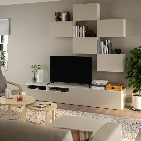 Dans un salon scandinave, un canapé positionné en face d'une télévison. La télévision est posée sur un meuble BESTA composé de façades beiges LAPPVIKEN.