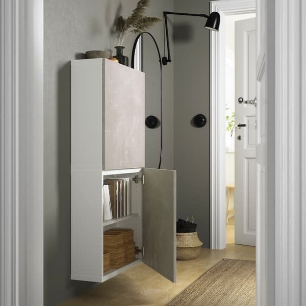 Dans une entrée, un meuble de rangement entre ouvert.
