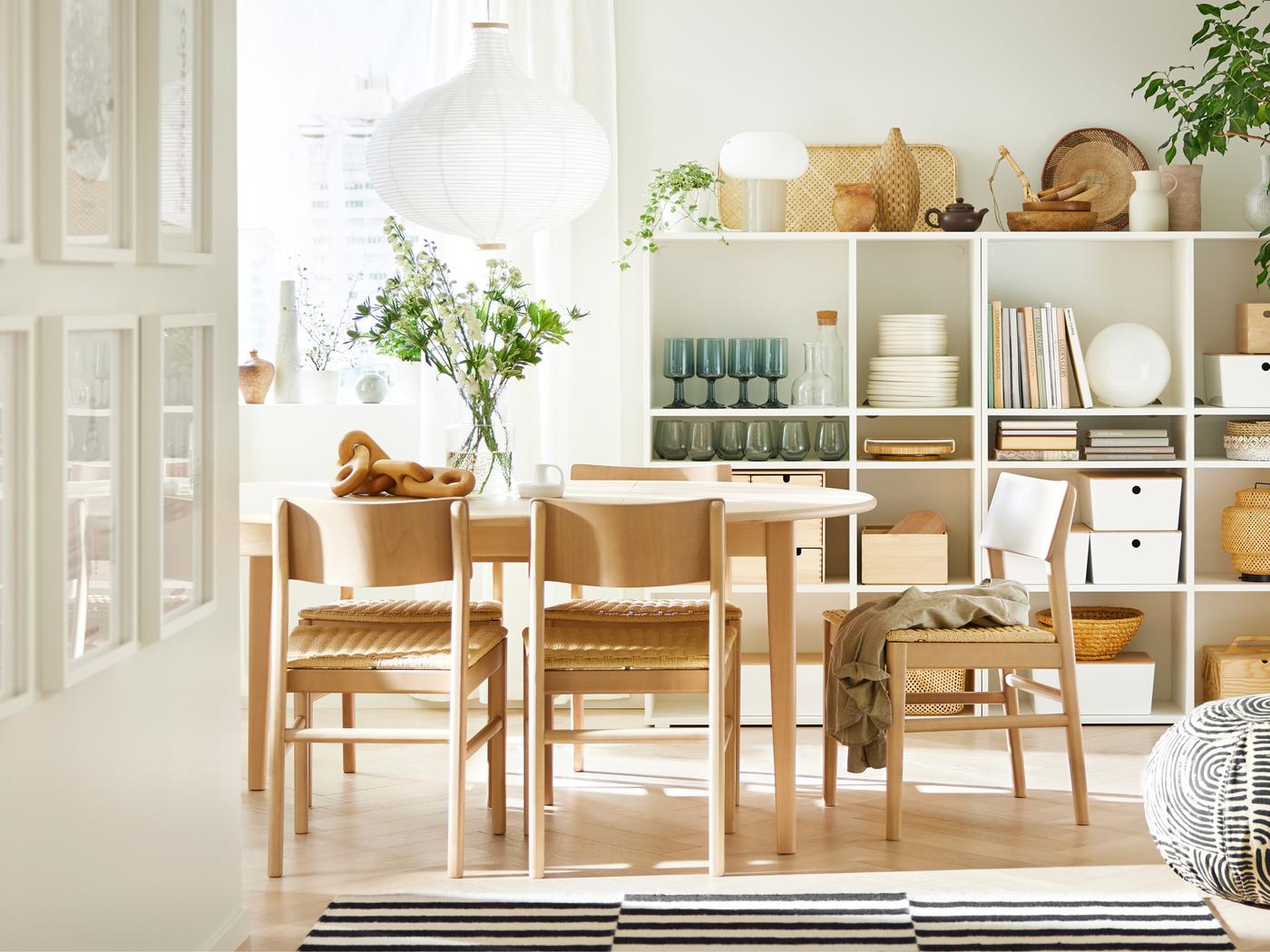 Dans une pièce au sol en bois, table ronde extensible SKANSNÄS plaquée hêtre clair et chaises SKANSNÄS en hêtre clair.
