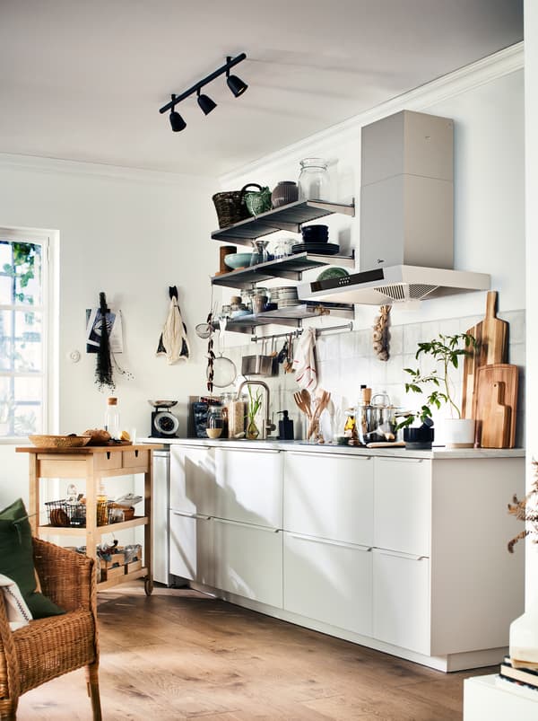Dapur berwarna hitam dan kelabu dengan warna kayu hangat dari lantai, aksesori dan troli dapur kayu FÖRHÖJA.