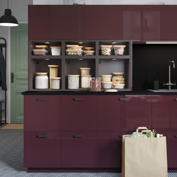 Dapur dilengkapi laci berkilat dan pintu berwarna merah coklat gelap dan kabinet terbuka antrasit TUTEMO mengandungi makan di dalam balang kaca.