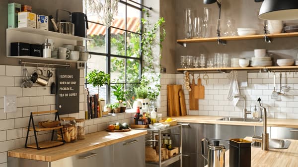 Dapur separa profesional yang besar dengan permukaan atas kerja dapur kayu, bahagian hadapan keluli tahan karat dan para terbuka untuk set makan malam.