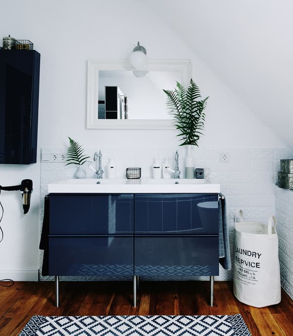 Dark bathroom cabinet and white walls create a calm, feelgood family bathroom.