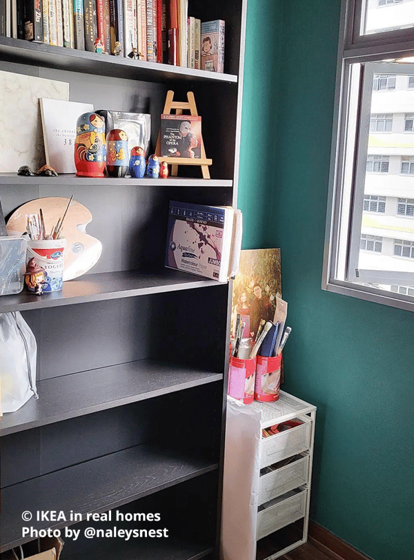 Dark brown BILLY bookcase in a study room at home with green walls, with books neatly arranged on the top shelf, and other decorative items displayed on other shelves. A LENNART mesh wire drawer is placed next to the bookcase with other items neatly stored. Photo by instagrammer @naleysnest for IKEA in real homes.