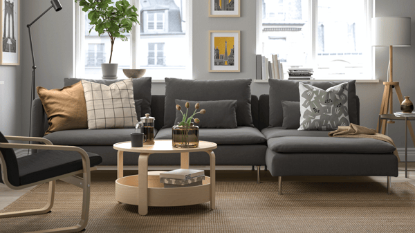 Dark grey SÖDERHAMN modular sofa in modern living room with monochrome accents, wooden coffee tables, and patterned cushions.