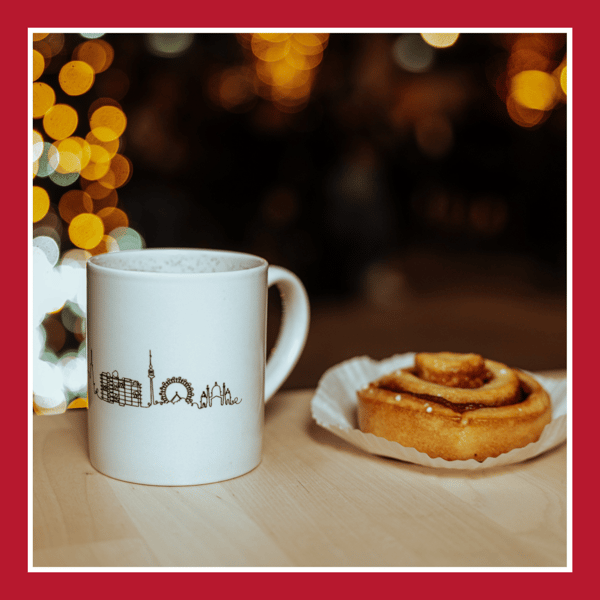 Das Bild zeigt eine Tasse Glögg, neben einer Zimtschnecke.