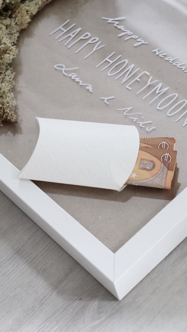 Das Geld wird in das Päckchen geschoben.
