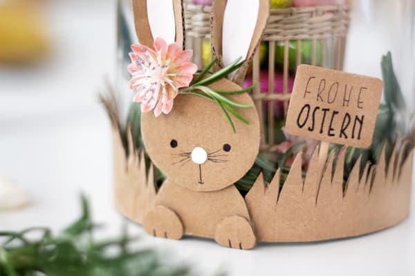 Das Häschen wird zusammen mit den Grasstreifen als Banderole um die Vase geklebt.