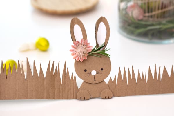 Das Papphäschen wird auf den Streifen Ostergras aus Pappe aufgeklebt.