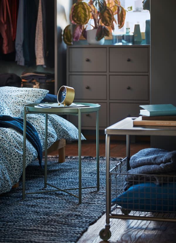 De lichte IKEA GLADOM salontafel met dienblad en de metalen LALLERÖD salontafel op wielen zijn flexibele, mobiele oppervlakken: je kan ze in huis overal meenemen om je glas of andere benodigdheden op te zetten.