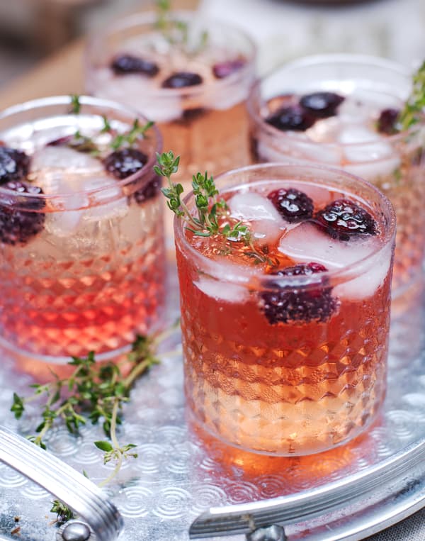 Decorate cocktail glasses with fresh berries and herbs.
