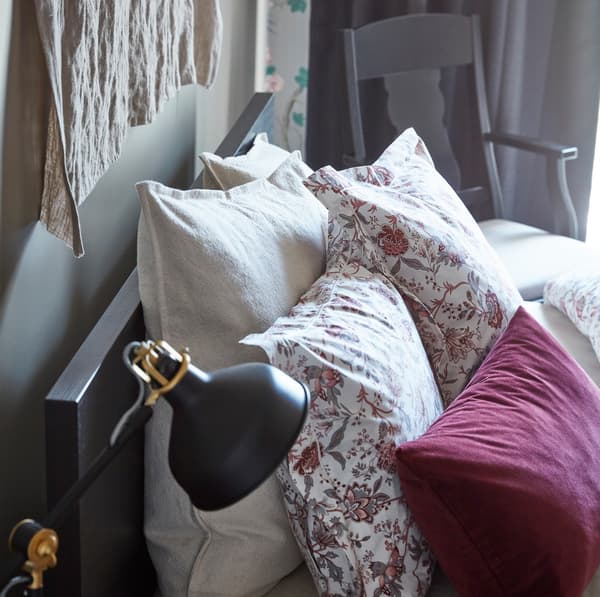 Decorate your IKEA MALM dark brown veneer bedframe with soft textiles and cushions like white-red floral patterned SPRÄNGÖRT and dark red velvet SANELA.
