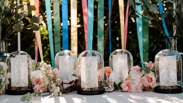 Décoration sous cloche sur une table ornée de fleurs roses en extérieur